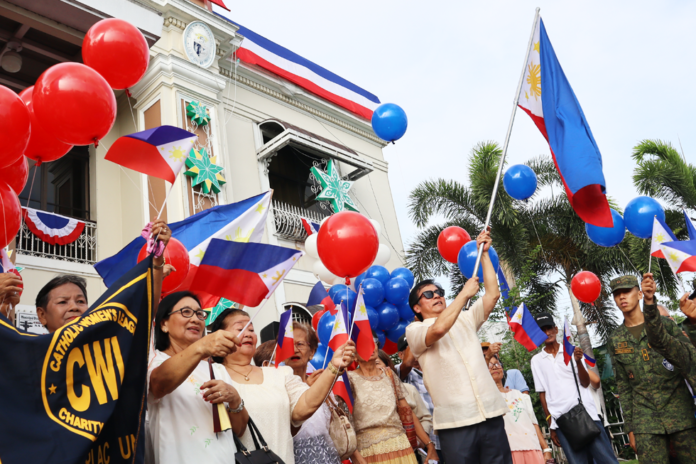 Mayor Noel Villanueva is seen here waving the Philippine flag during the 126th anniversary celebration of Philippine Independence in the town of Concepcion, Tarlac.