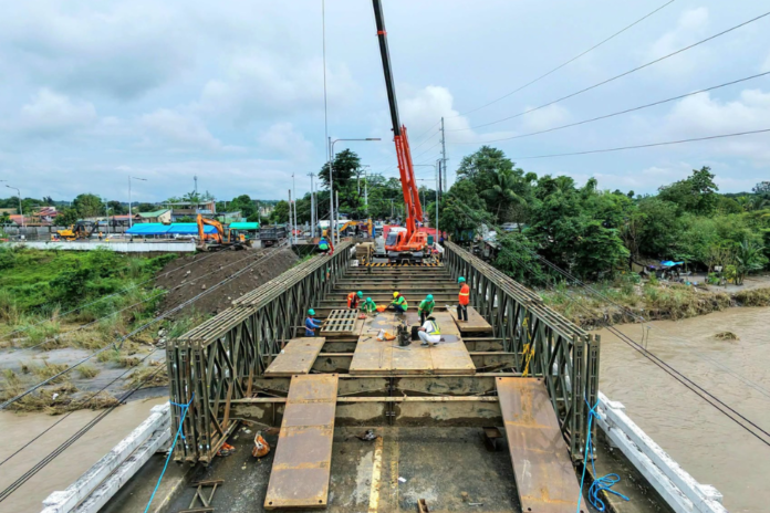 DPWH workers continue construction of the temporary Bailey bridge at the damaged Agana Bridge in Tarlac City. (Image credited: Susan Yap)