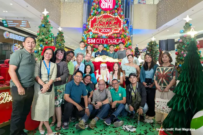 Members of the local media giddily pose for pictures with Santa.