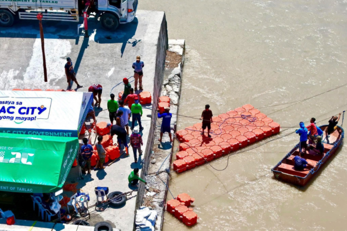 Workers begin installing pontoon units at the Tarlac River. (Image Credited: Mayor Susan Yap)